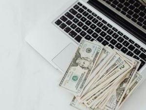 BIlletes de dolares americanos encima de una laptop