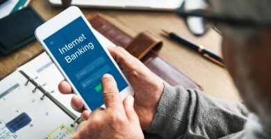 persona con smartphone entra en un aplicacion del banco. Como comprar criptomonedas en bbva