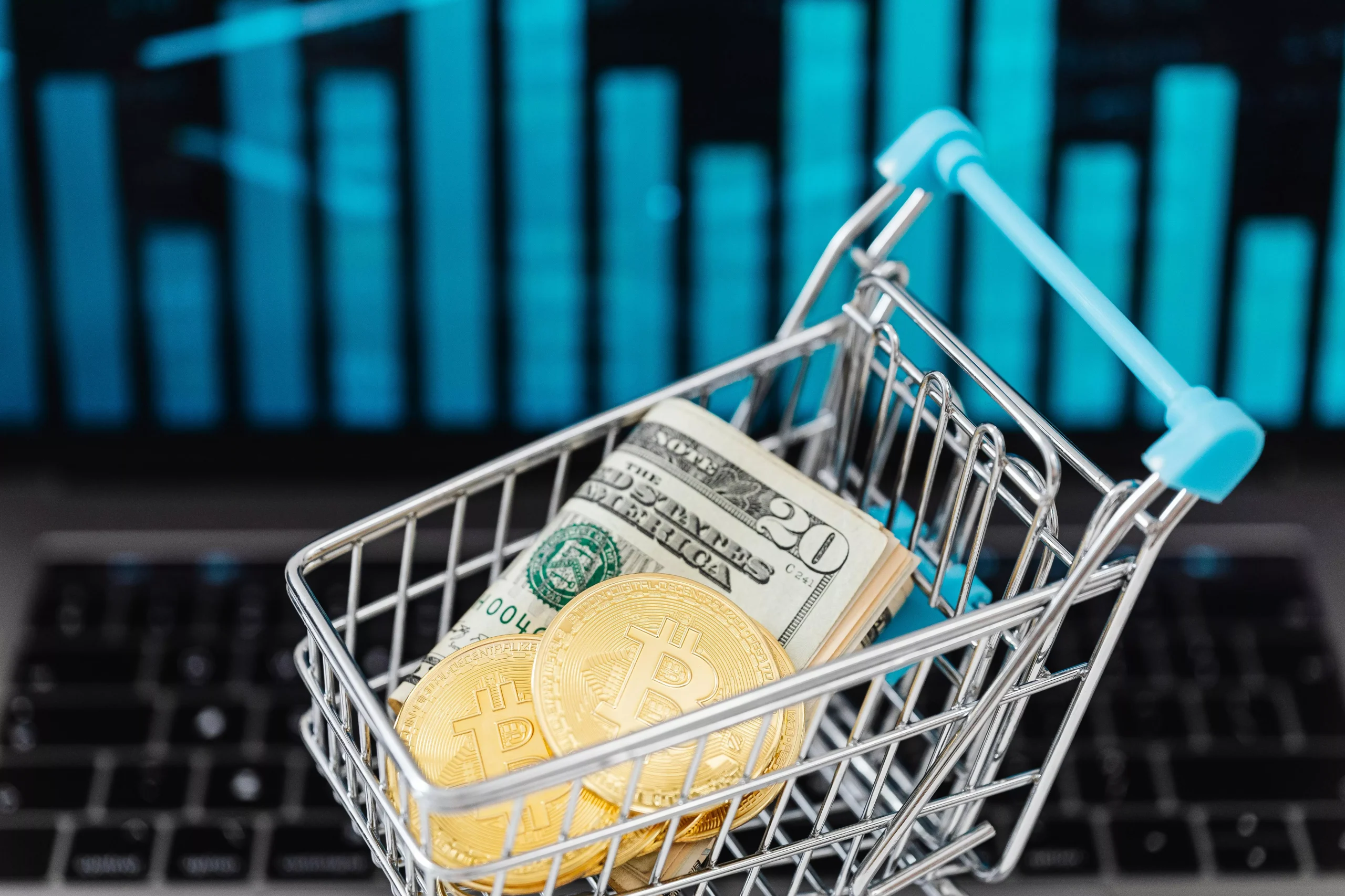 fotografia de un carrito de compras miniatura cargando un billete de dolar y un token de btc para respresentar por que la criptomoneda tiene valor