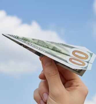 Persona sosteniendo un billete de cien dolares que envia la remesa.