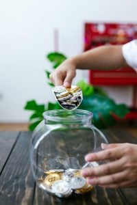 Imagen de estock sobre una mano guardonda tokes que son las stablecoins​ en un jarron de vidrio.