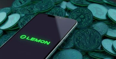 Smartphone con el logo de Lemon Cash y Bitcoins de fondo