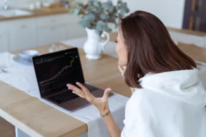 mujer-videndo-grafica-de-exchange-en-su-laptop mujer en su laptop analiza la subida de precio de btc